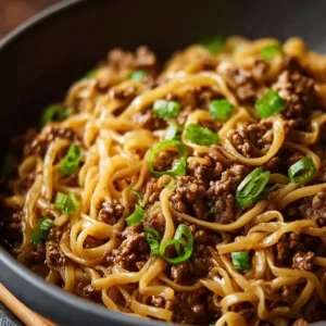 Mongolian ground beef noodles served in a bowl with fresh vegetables