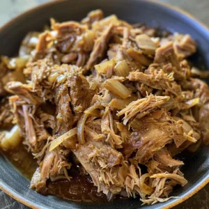 Classic slow cooker pulled pork dish served with BBQ sauce