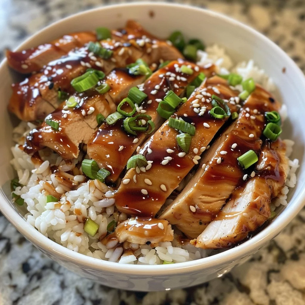 Honey Garlic Chicken Rice Bowl garnished with green onions and sesame seeds