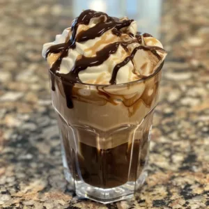 Delicious mocha iced coffee in a glass with whipped cream on top.