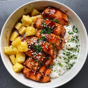 Delicious teriyaki salmon pineapple bowl garnished with fresh herbs